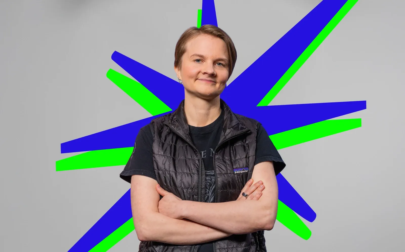 Mari Luukkainen kädet puuskassa sinisen ja vihreän tähtikuvion edessä.